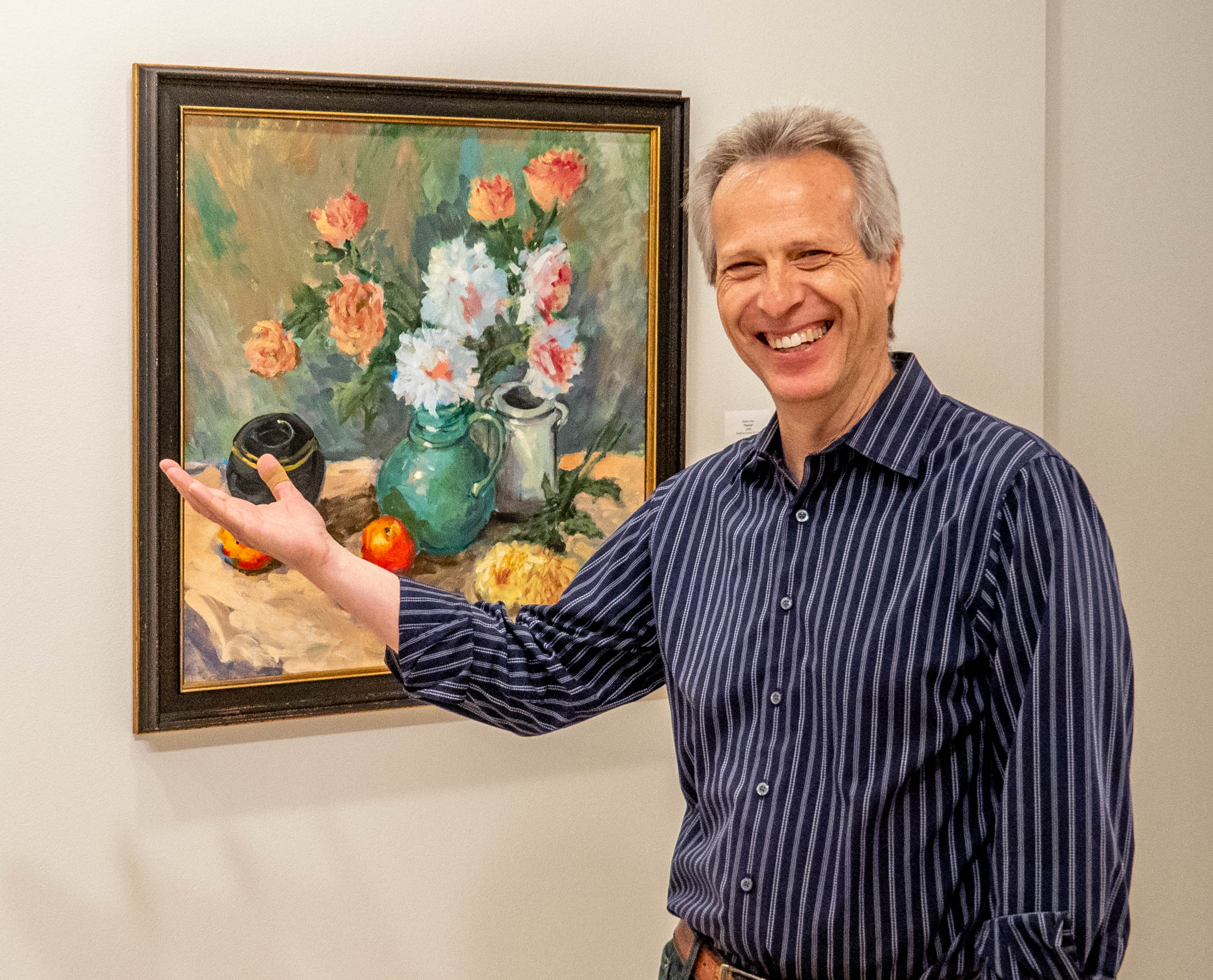 Mutlu Ertaç with a framed still life of flowers and fruit